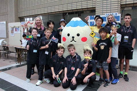 Children and people posing for a photo in a hall