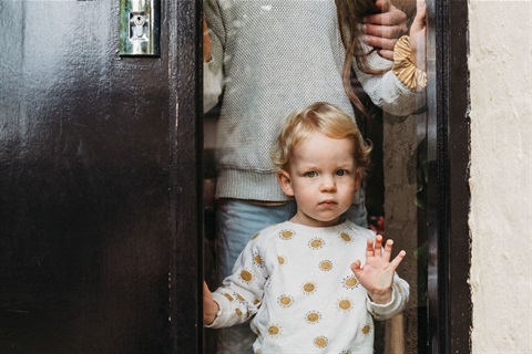 Child looking out behind a glass